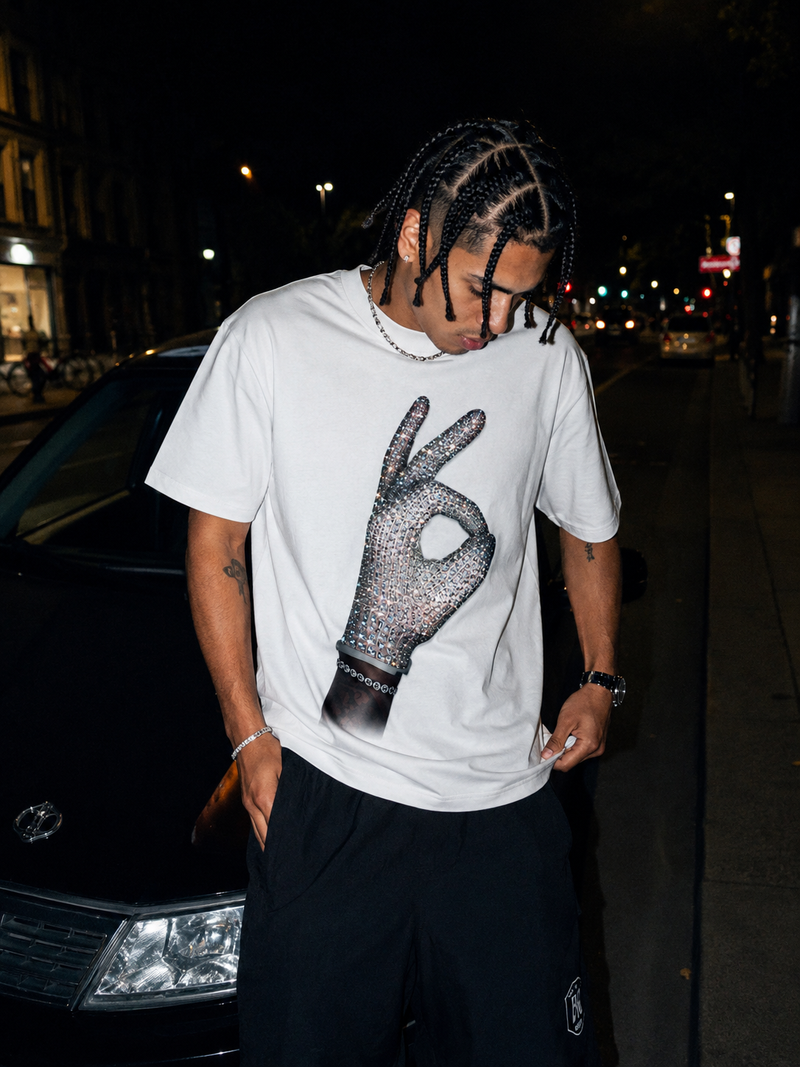 Young man wearing ICEMAN white tee with rhinestone hand print, urban street night photography — Drake ICEMAN album inspired heavyweight boxy streetwear
